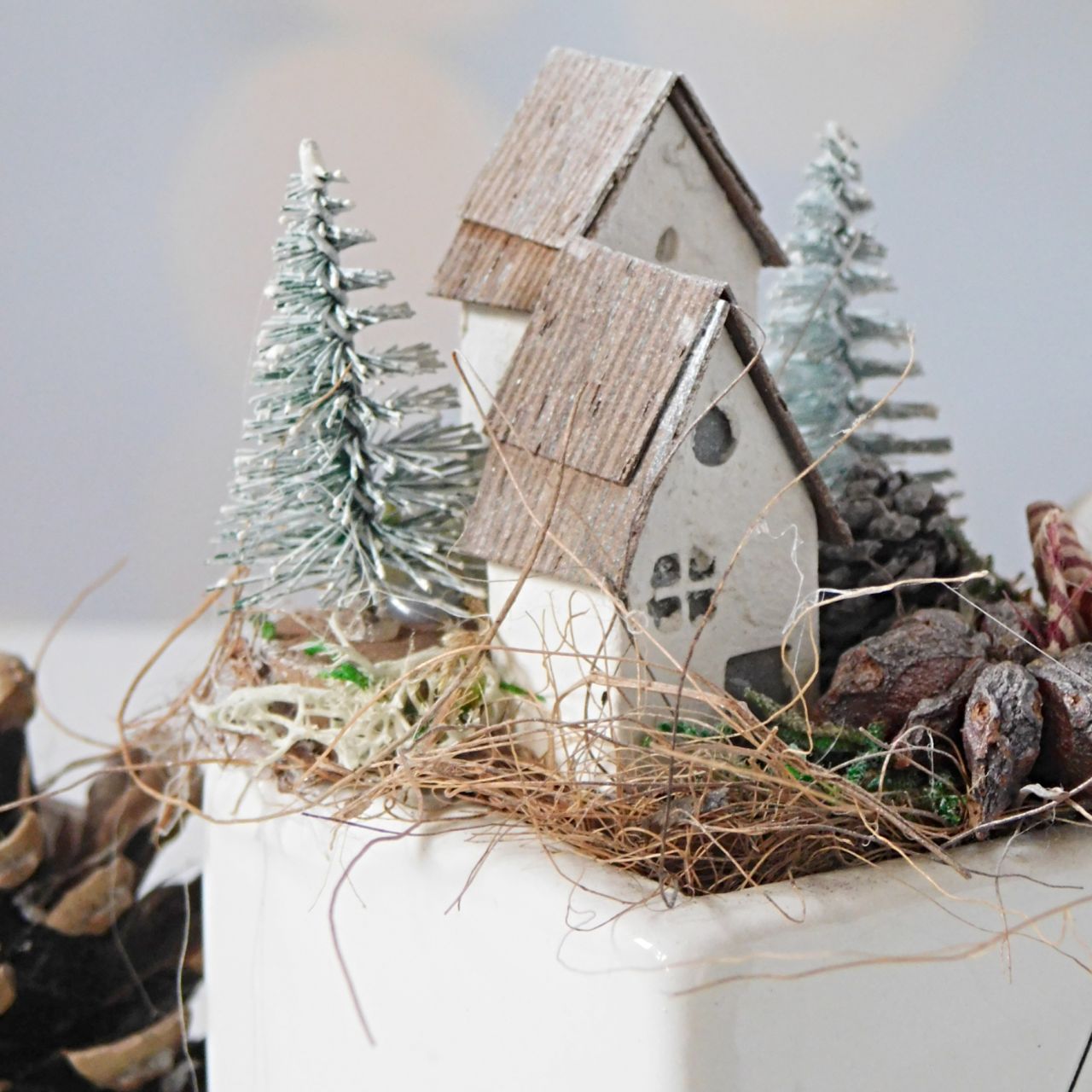 Karácsonyi asztaldísz – fehér kocka kaspó két apró házikóval